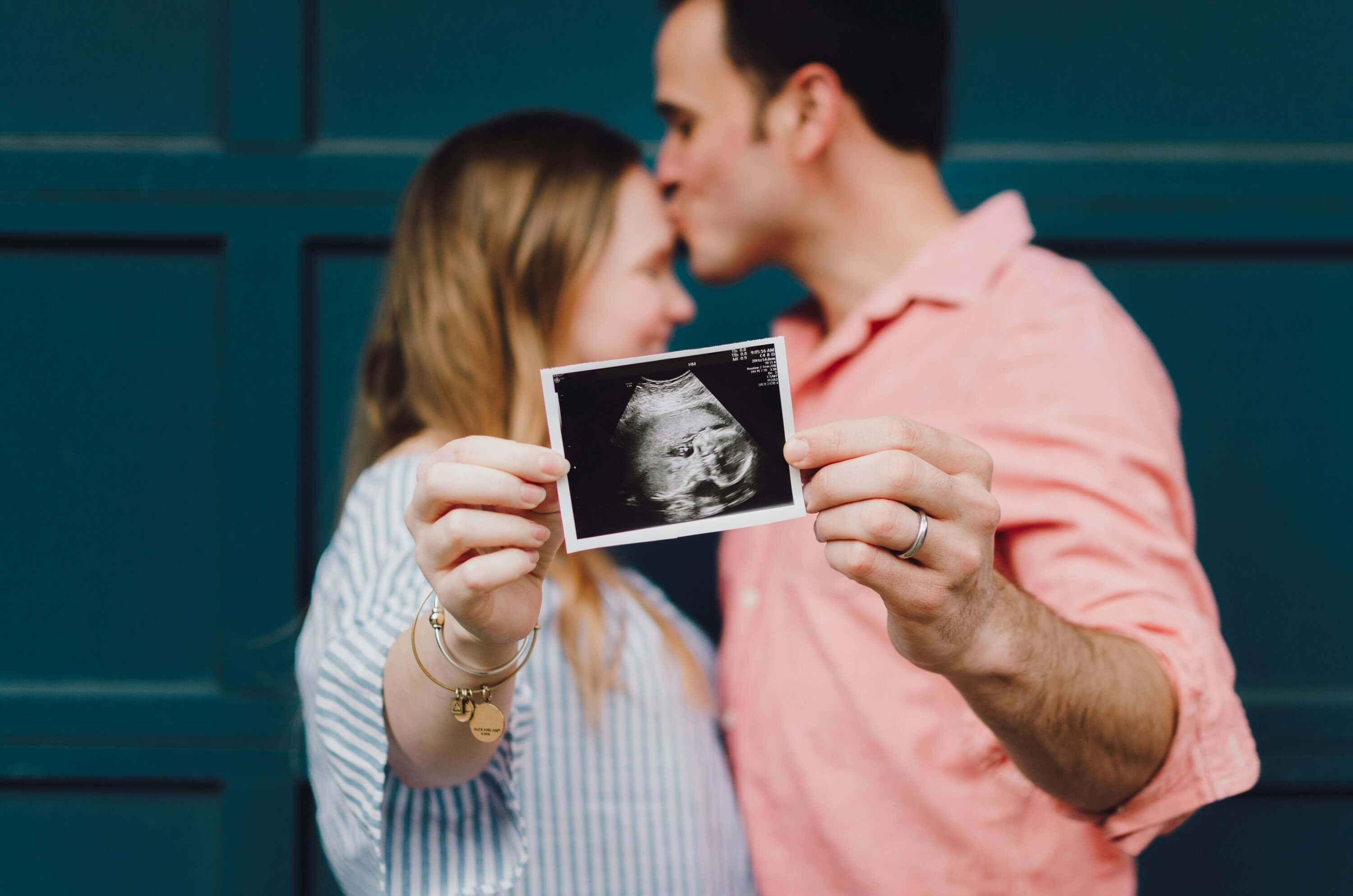 Expecting couple holding ultrasound photo